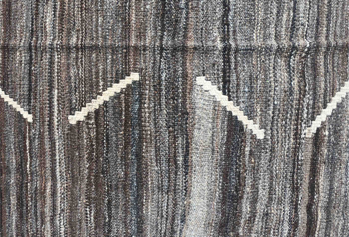 Detalle de motivos geométricos en alfombra Kelim de lana con tejido plano