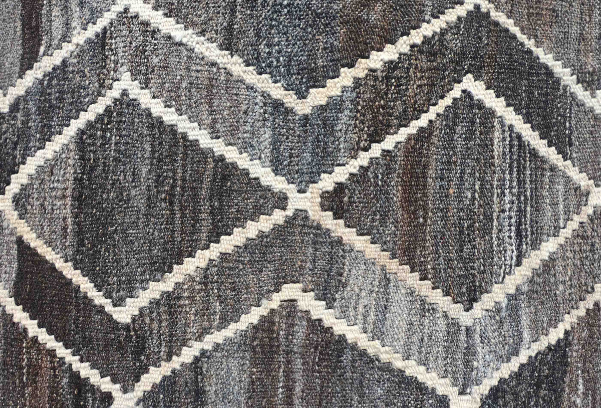Detalle de motivos geométricos en alfombra Kelim de lana, tejido plano reversible