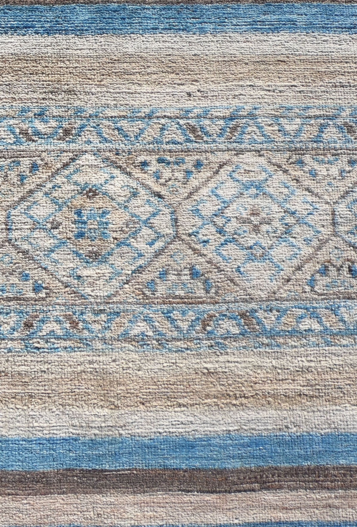 Detalle geométrico lineal en alfombra persa de lana natural