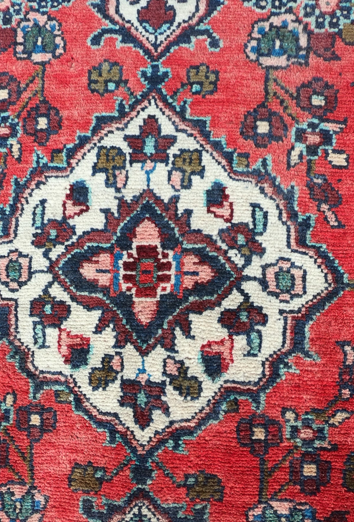 Detalle de motivos florales y medallón en alfombra persa turca de lana