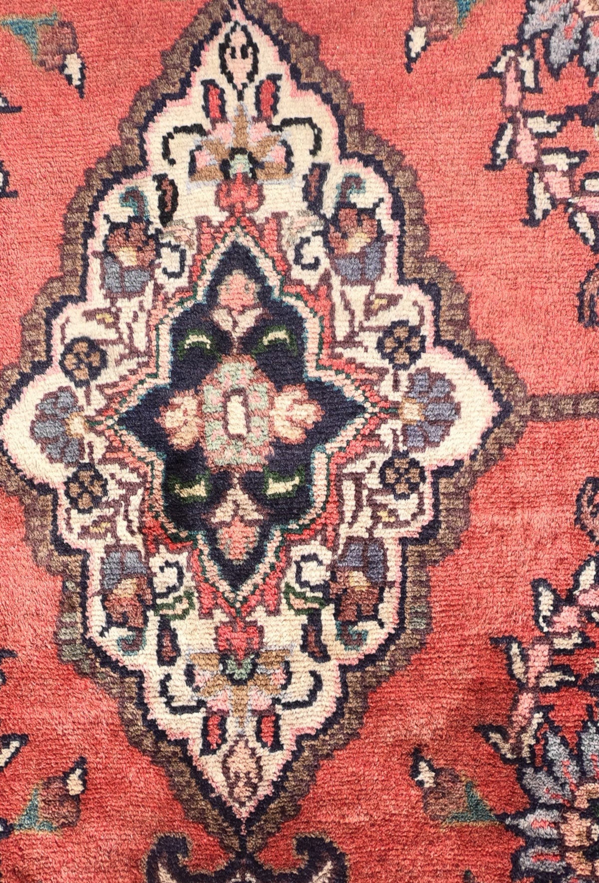 Detalle de motivos florales y medallón en alfombra persa de lana turca