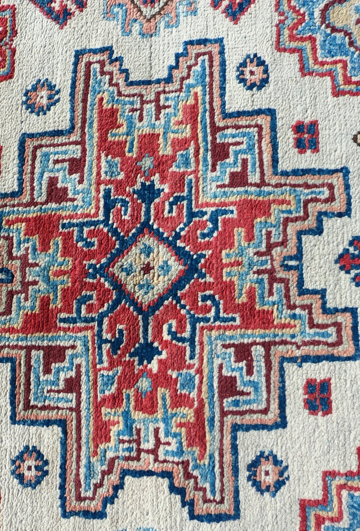 Detalle patrón geométrico intenso en alfombra persa de lana Kazak
