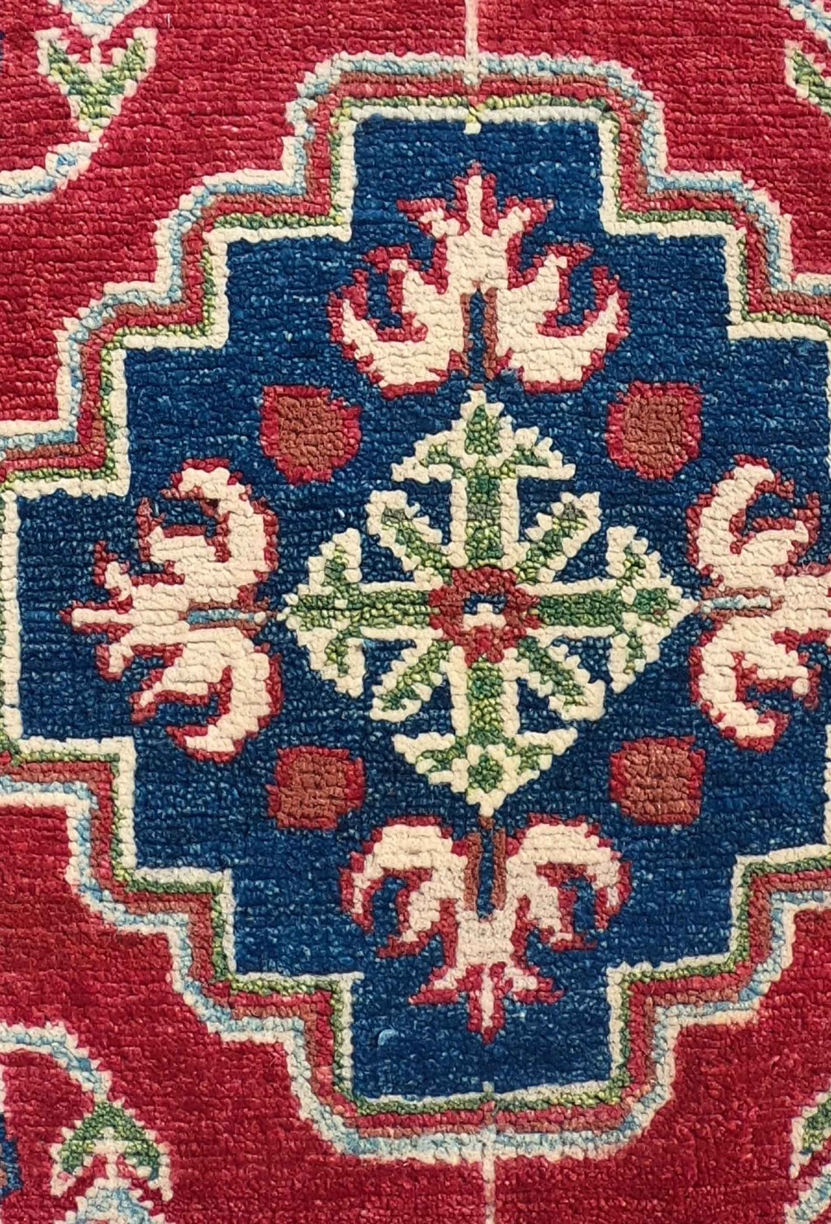 Detalle del diseño geométrico en alfombra Kazak de lana pakistaní