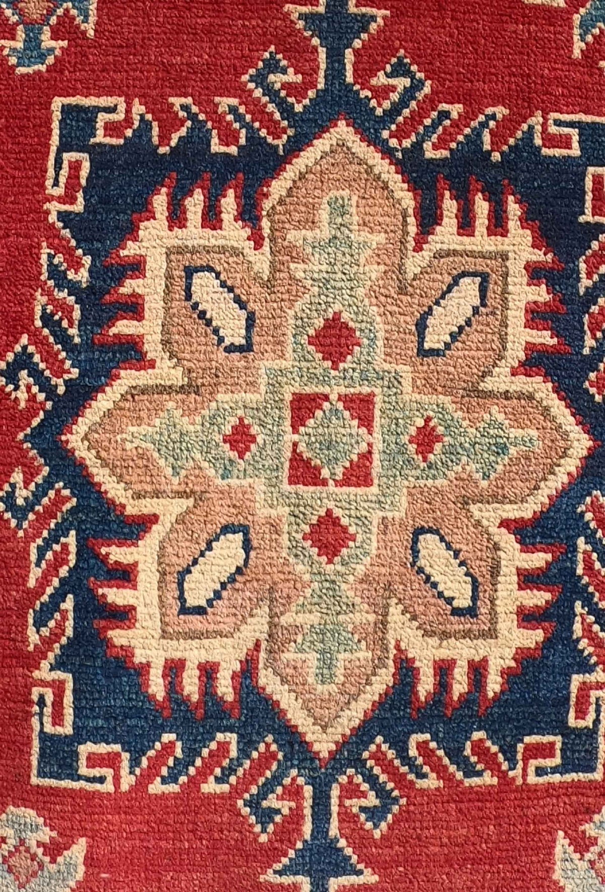 Detalle del tejido a mano de alfombra Kazak pakistaní