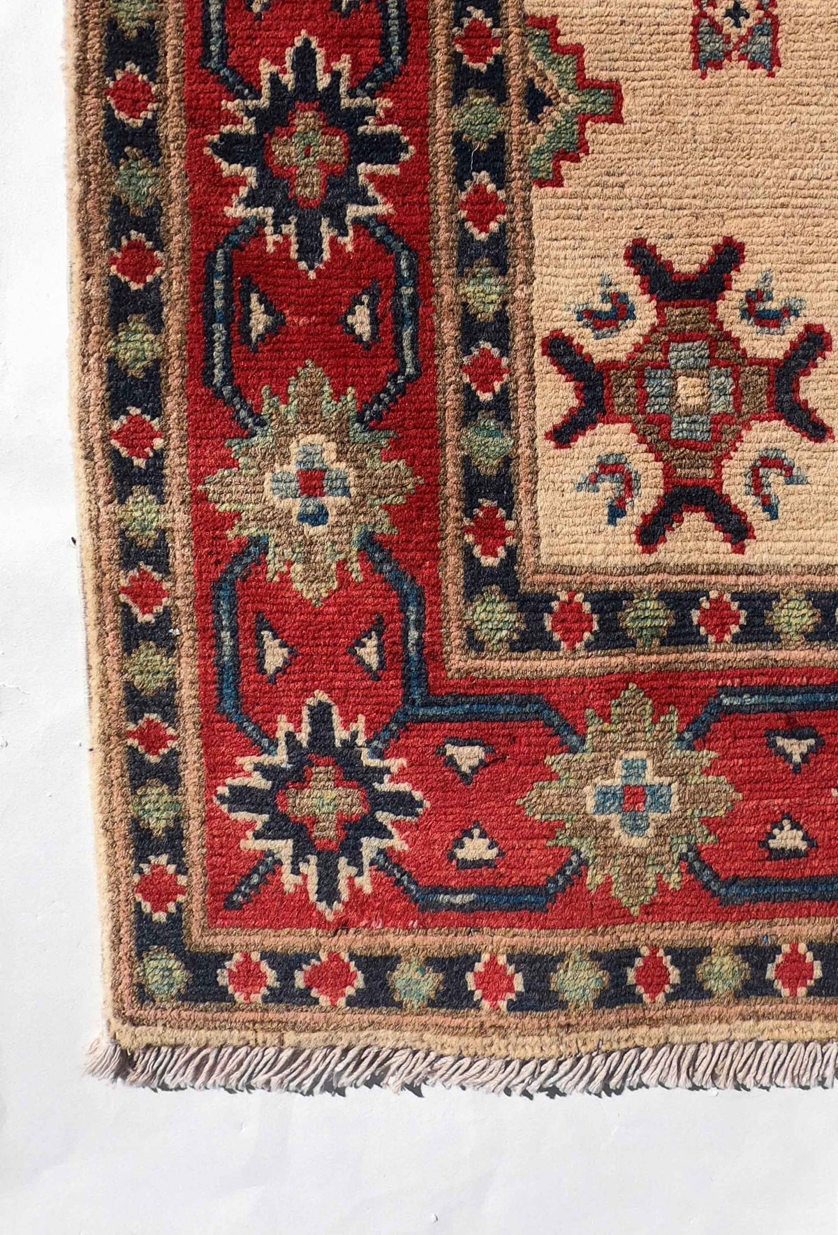 Alfombra Kazak de lana en ambiente de dormitorio clásico.
