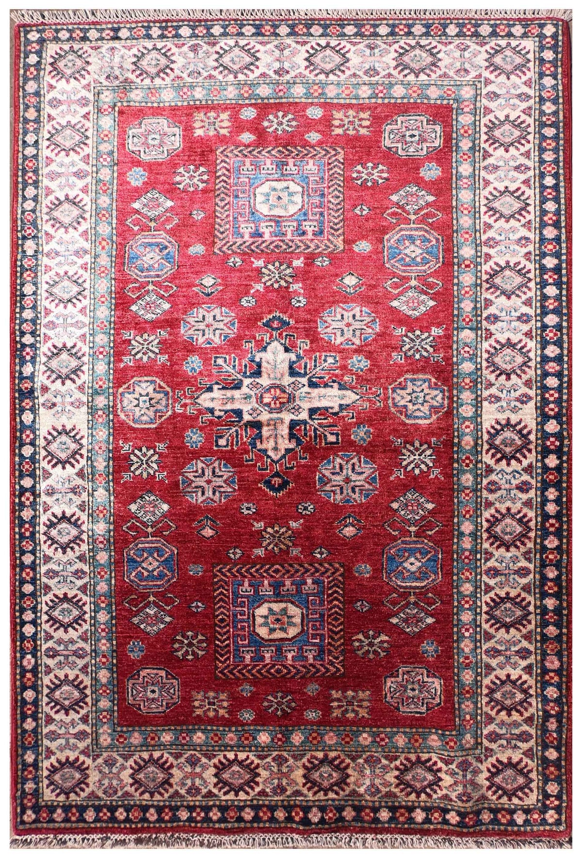 Alfombra persa Kazak Ghazni de lana con diseño floral rojo y azul.