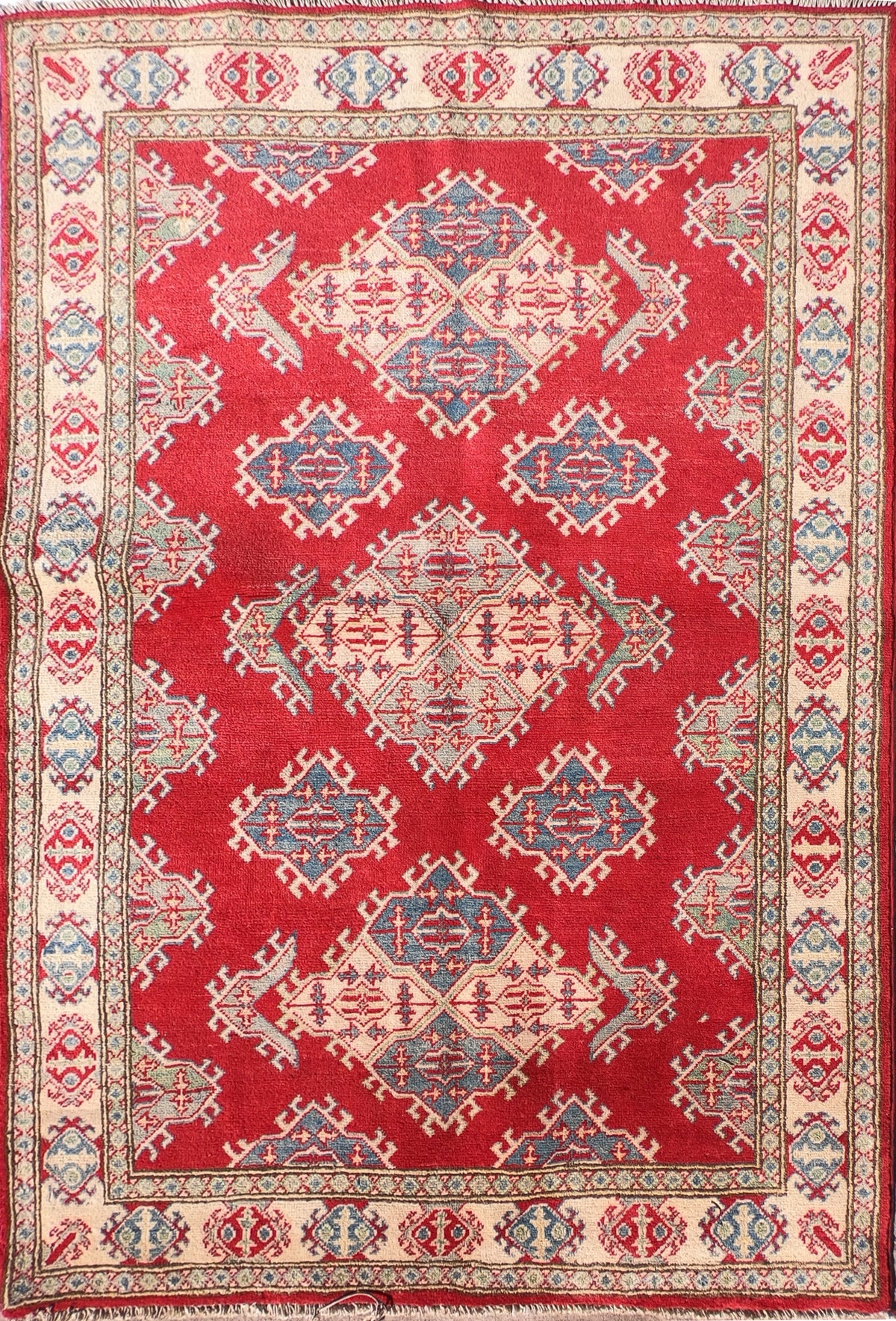 Alfombra persa Kazak de lana roja sobre fondo neutro