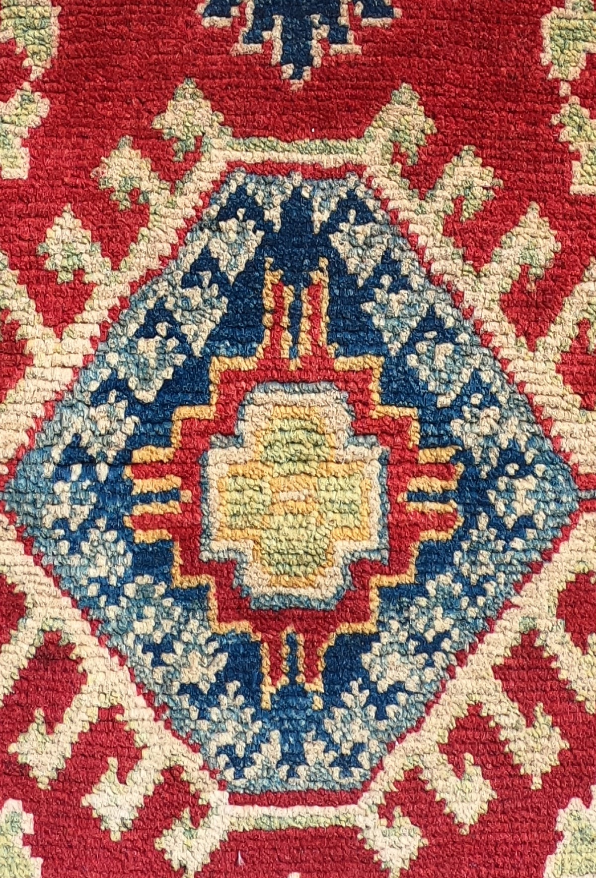 Detalle de la trama de lana de alfombra Kazak pakistaní