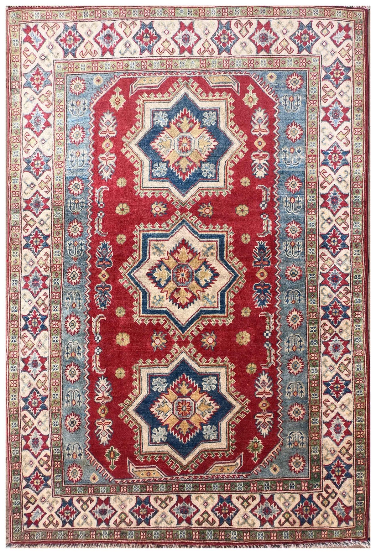 Alfombra persa Kazak de lana con diseño geométrico rojo, ideal para living