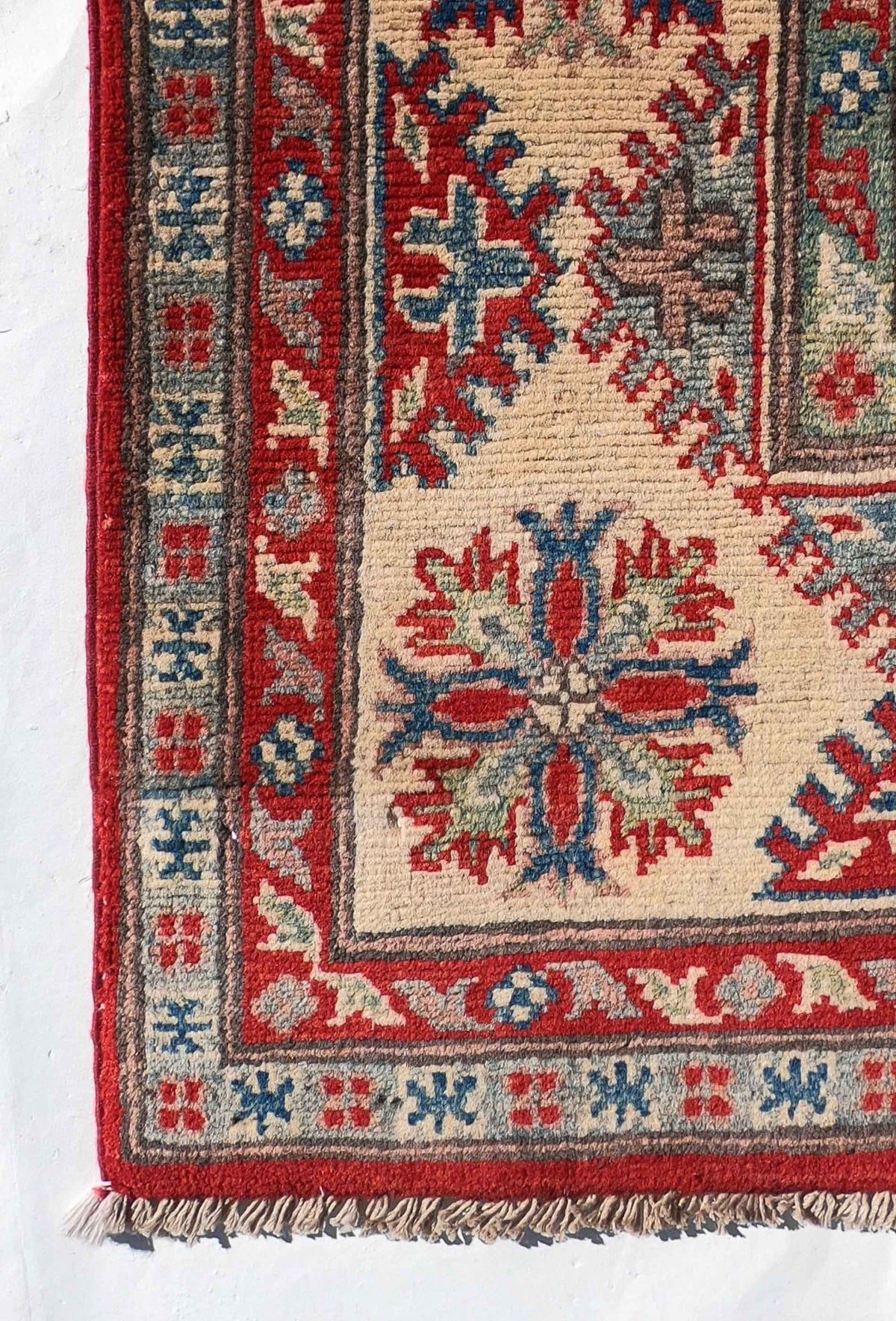 Detalle de la trama de lana de la alfombra persa Kazak