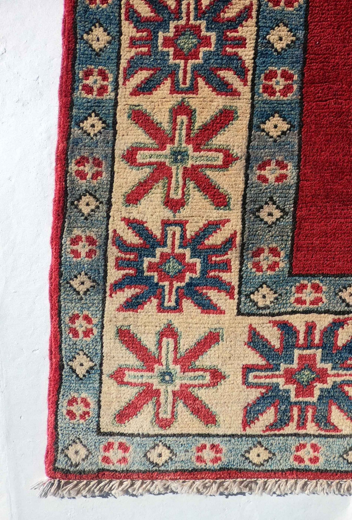 Alfombra Kazak de lana en ambiente de sala de estar