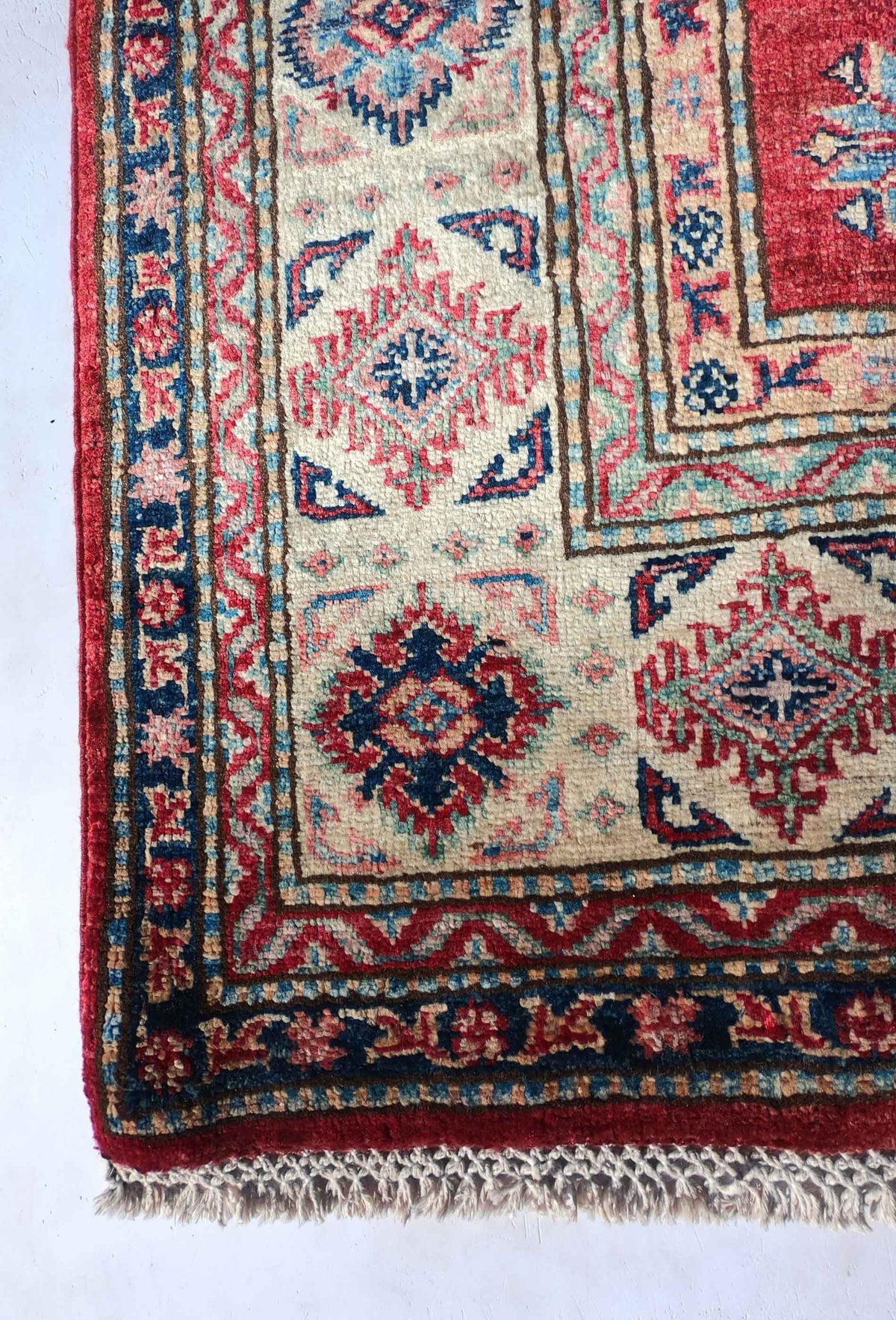 Detalle de la textura de la alfombra persa Kazak Ghazni de lana.