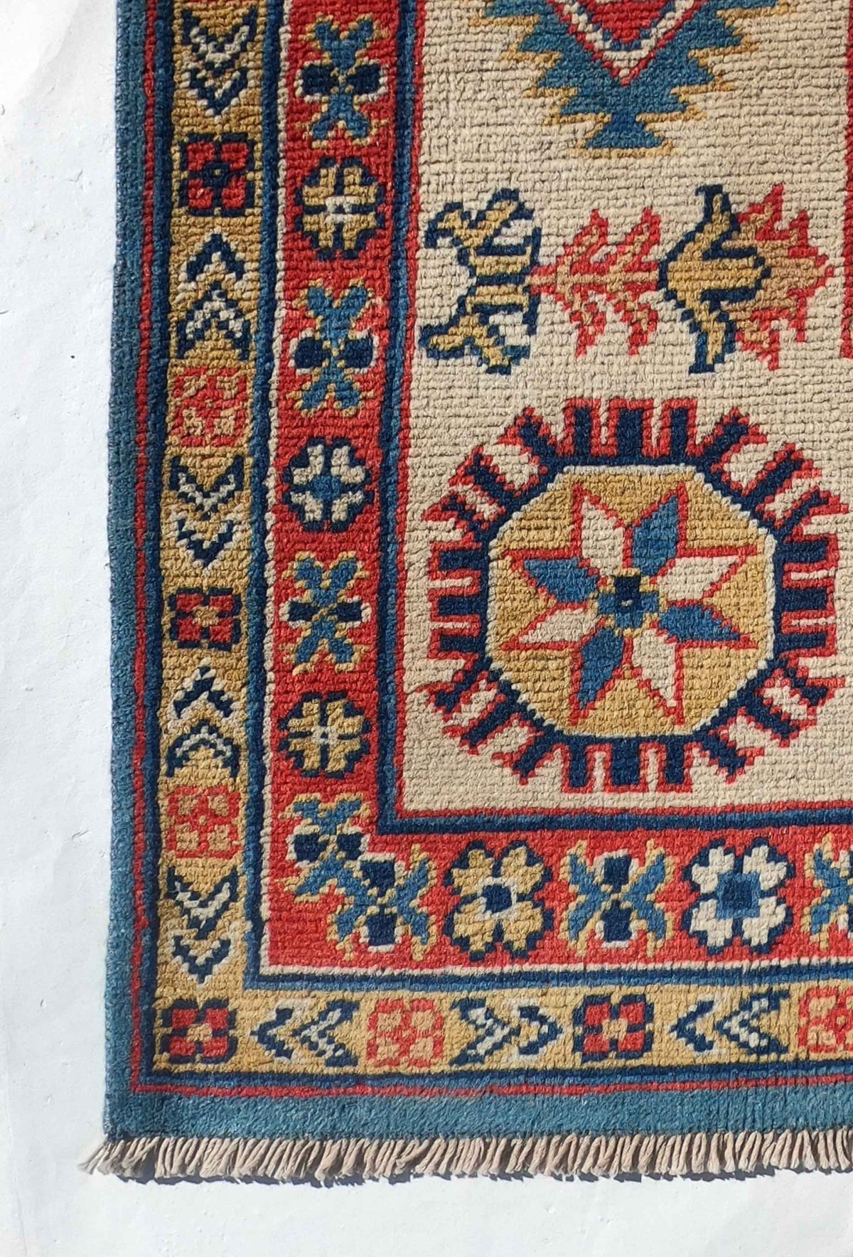 Detalle del diseño geométrico de alfombra Kazak persa