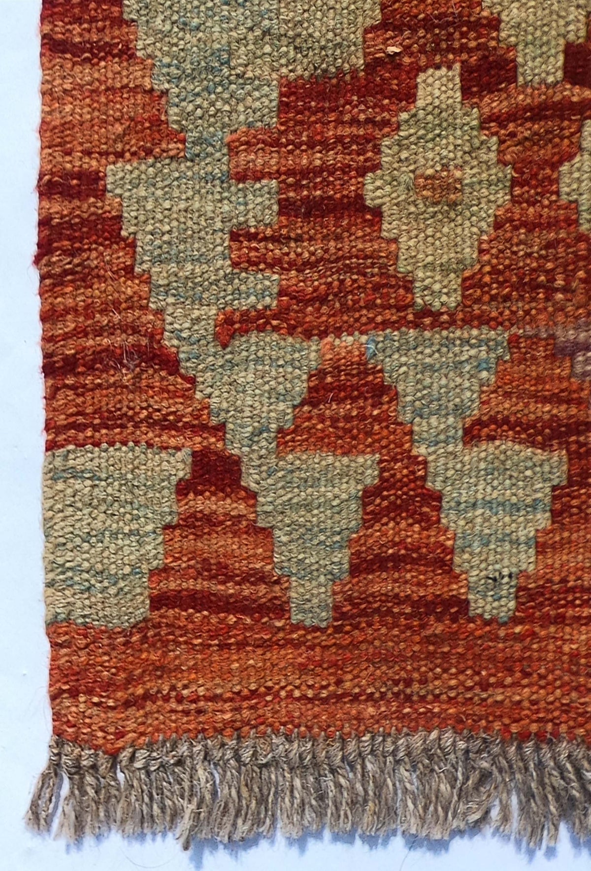 Textura de lana natural en alfombra Kelim artesanal, teñida con tintes naturales