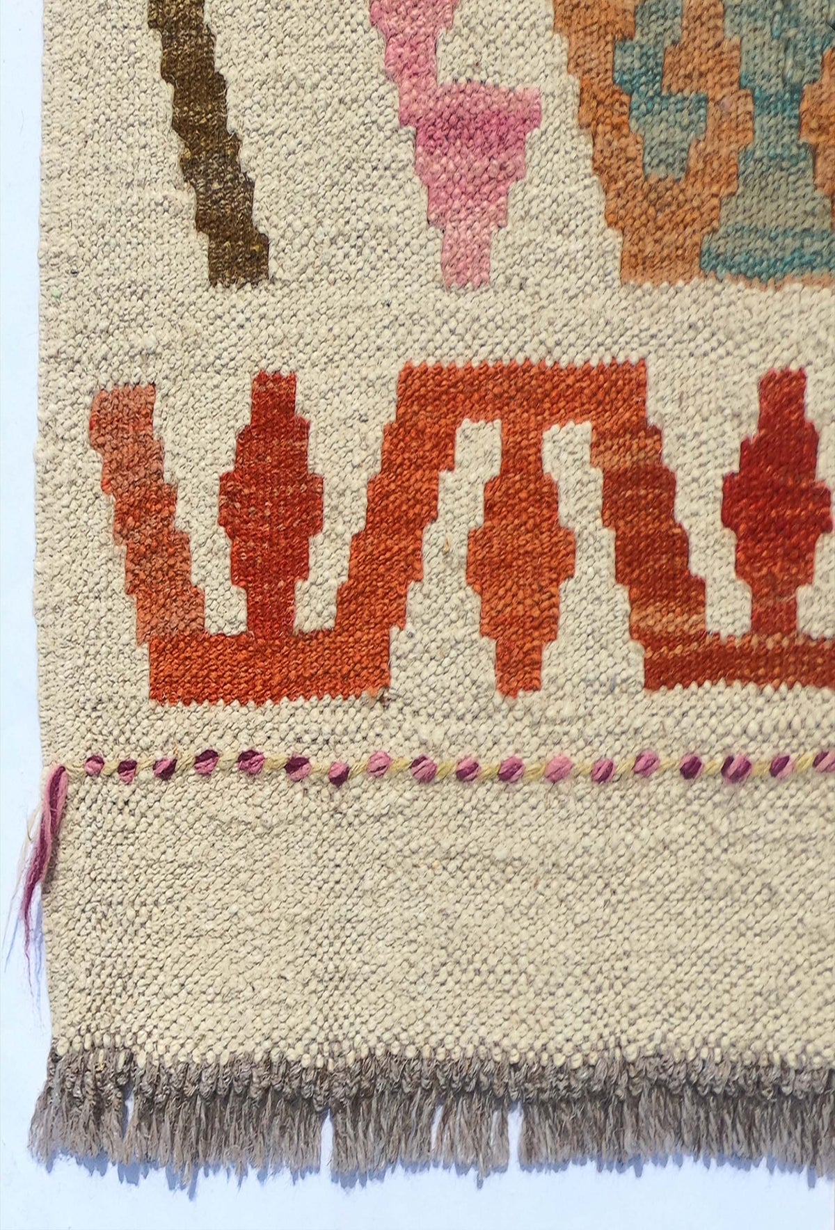 Detalle de patrón geométrico en alfombra kelim de lana con tintes naturales