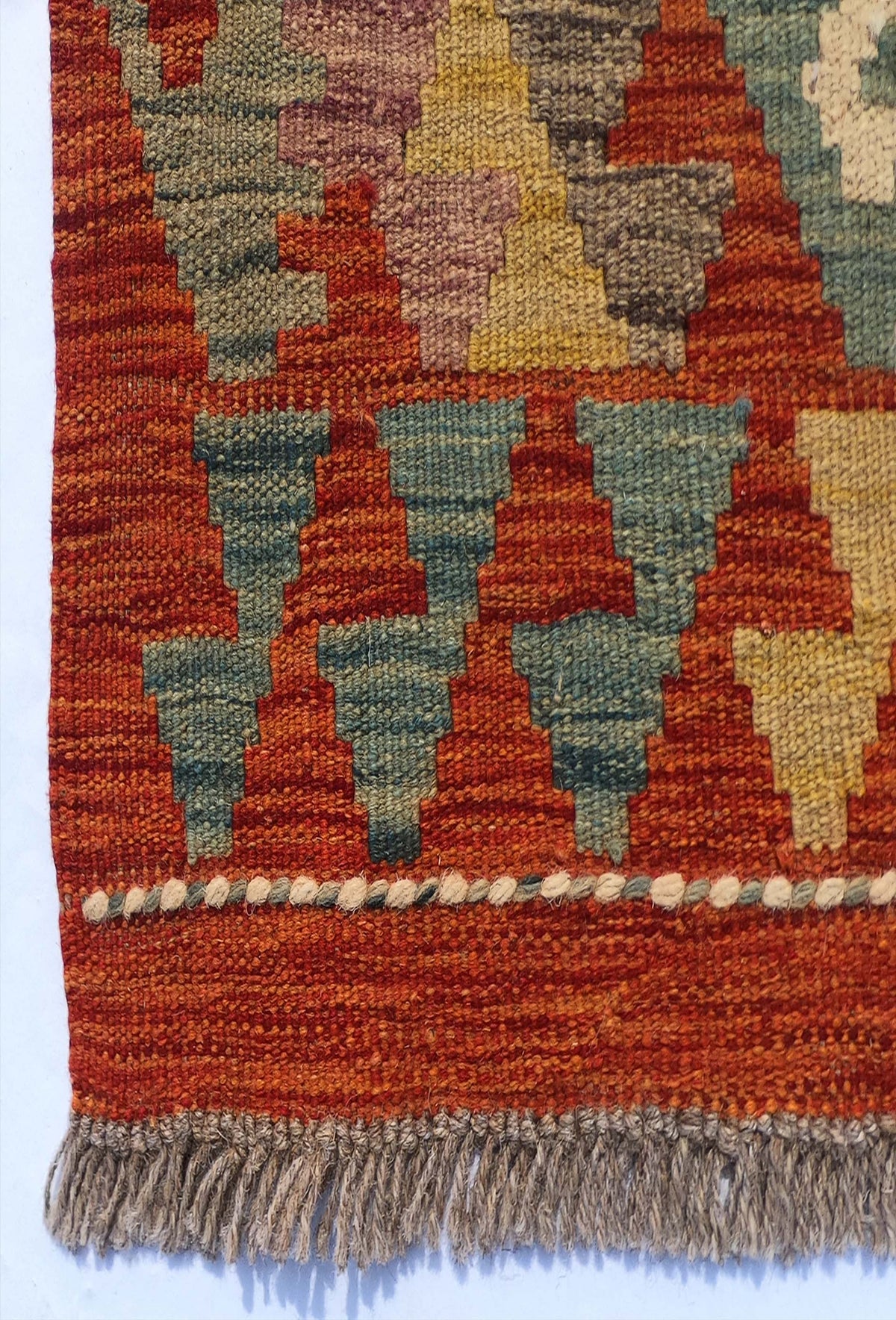 Textura de lana natural en alfombra Kelim artesanal, teñida con tintes naturales