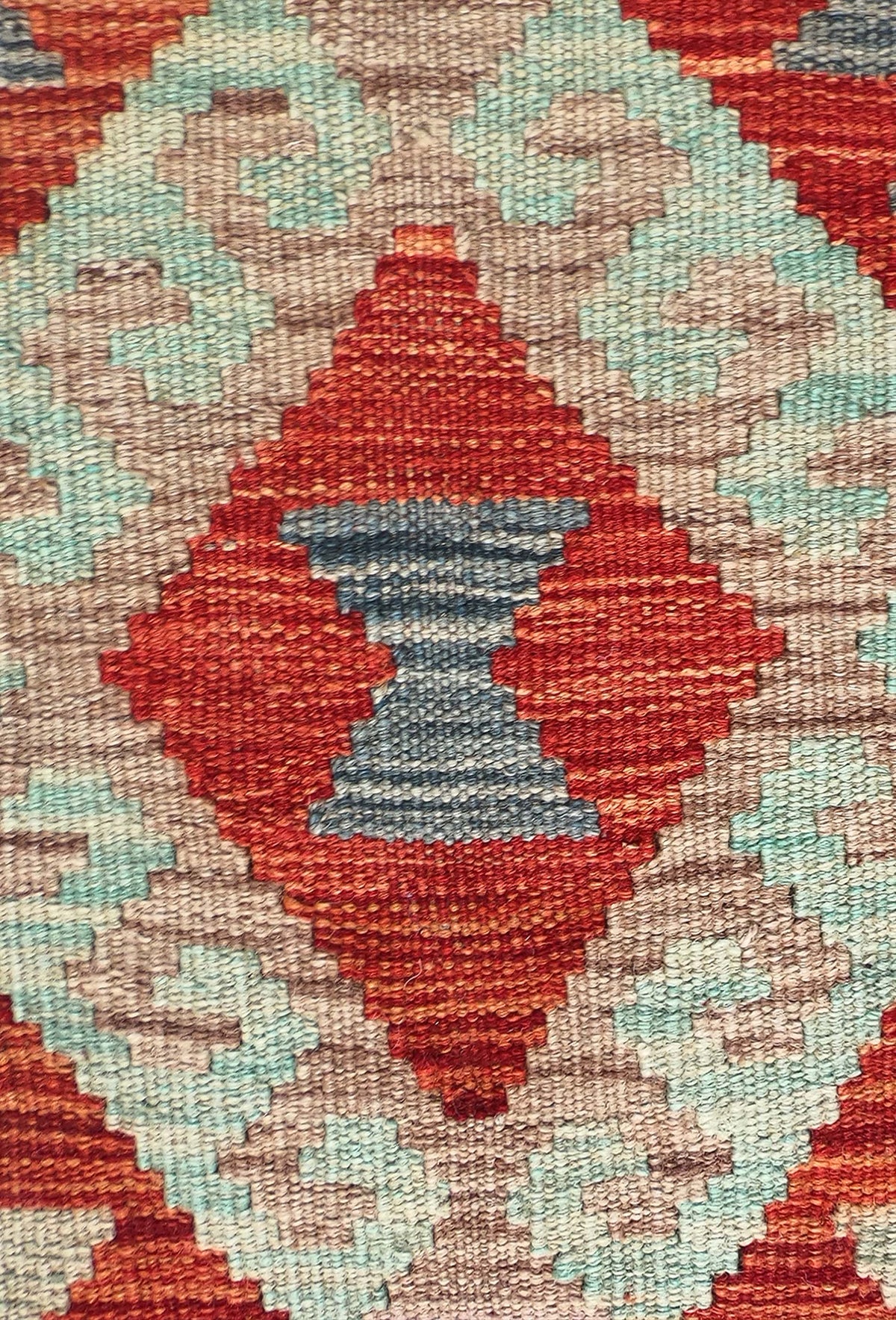Detalle de motivos geométricos en alfombra kelim de lana teñida con tintes naturales