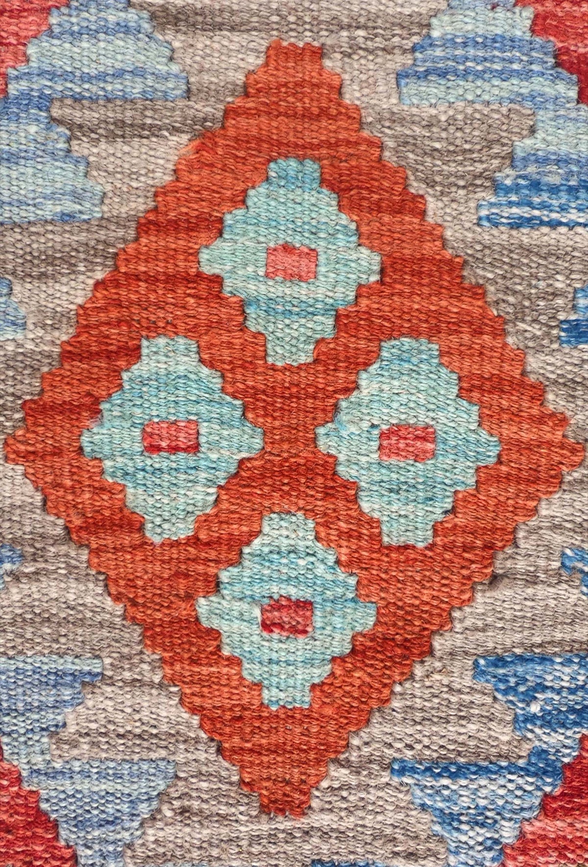 Detalle de motivos geométricos en alfombra kelim de lana, tejido plano