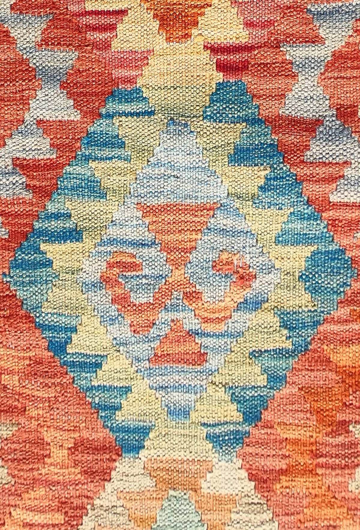 Detalle de motivos geométricos en alfombra kelim de lana importada