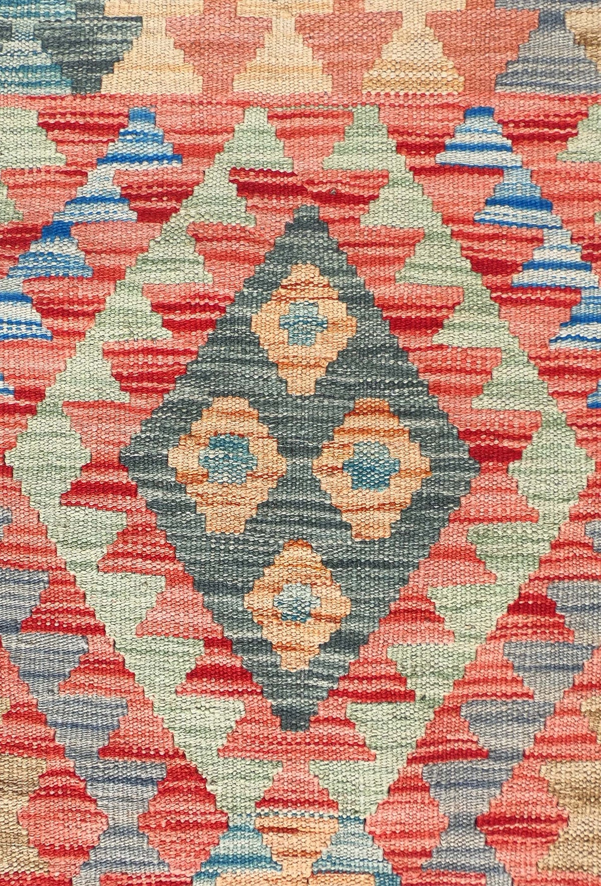 Detalle de motivos geométricos coloridos en alfombra Kelim de lana