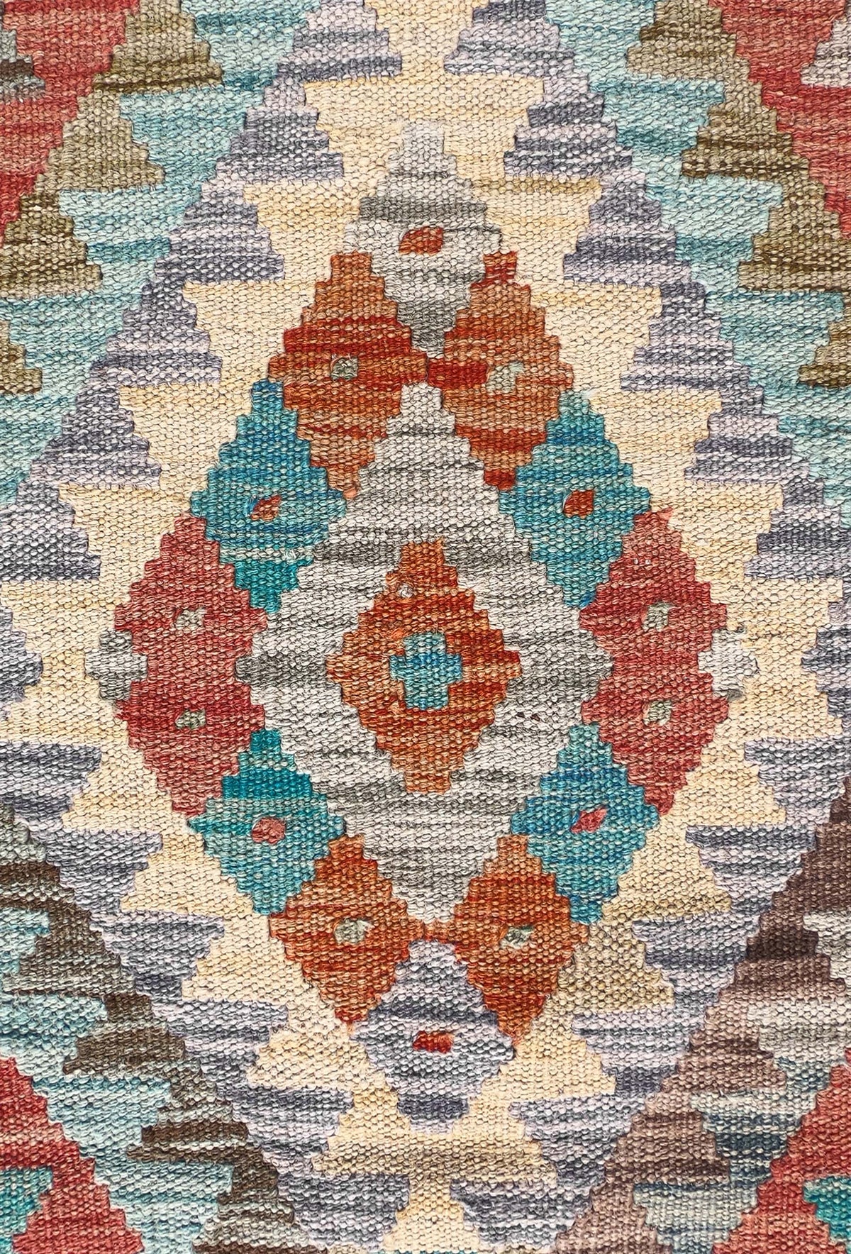 Detalle de motivos geométricos coloridos en alfombra Kelim de lana