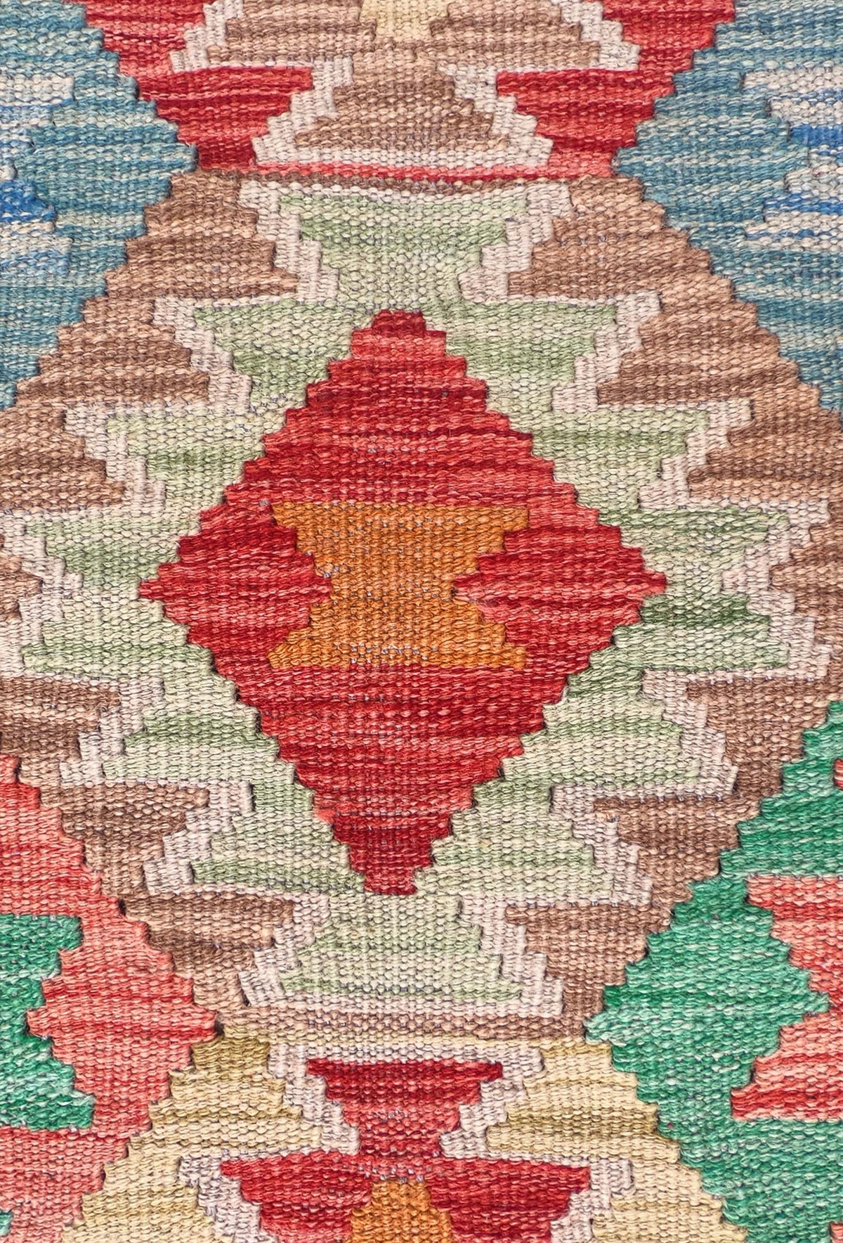 Detalle de motivos geométricos en alfombra Kelim de lana tejida en telar