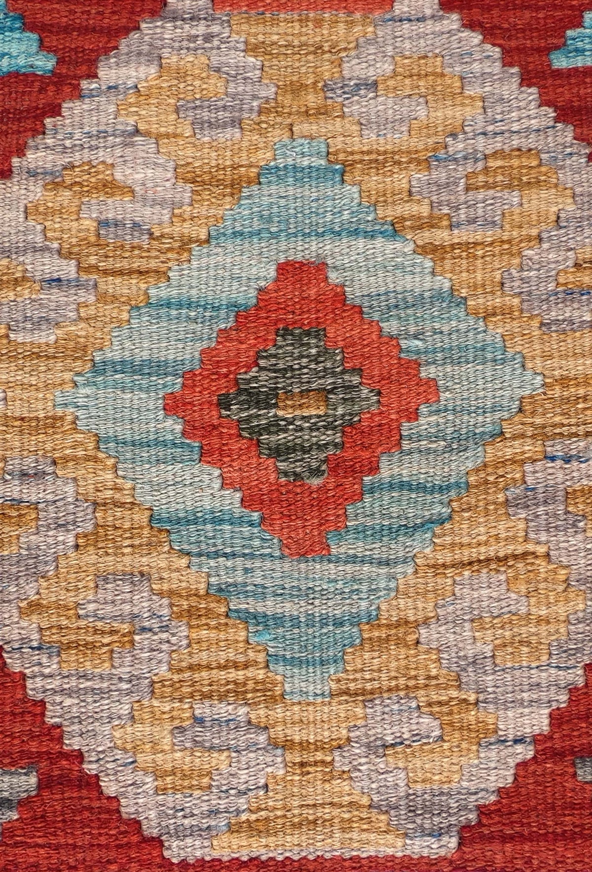Detalle de motivos geométricos en alfombra Kelim de lana tejida a mano