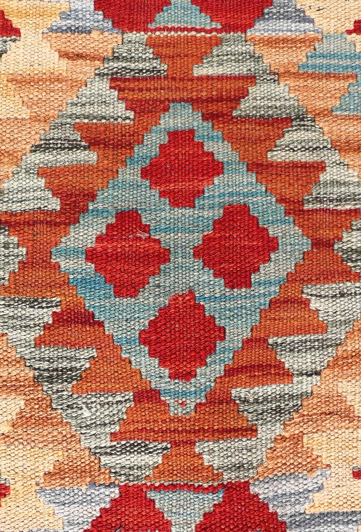 Detalle de motivos geométricos coloridos en alfombra Kelim de lana