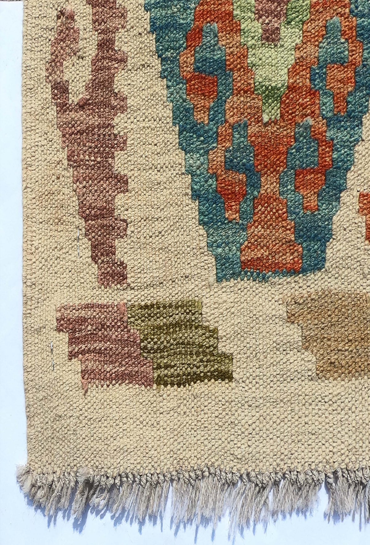 Textura de lana natural en alfombra Kelim artesanal, teñida con tintes naturales
