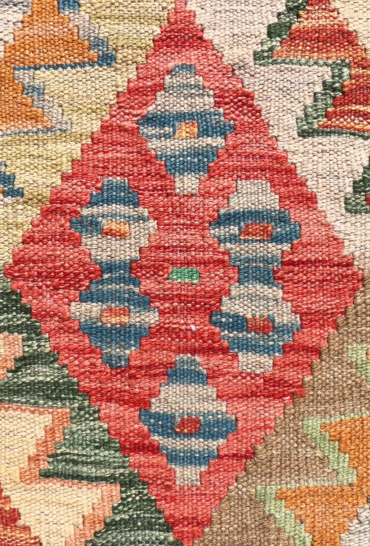 Detalle de motivos geométricos en alfombra Kelim tejida a mano