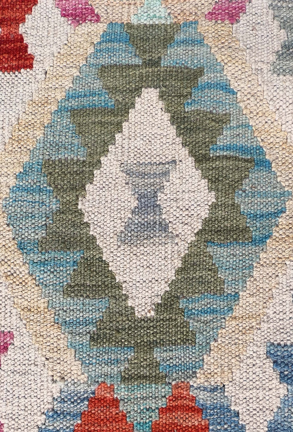 Detalle de motivos geométricos en alfombra Kelim tejida a mano
