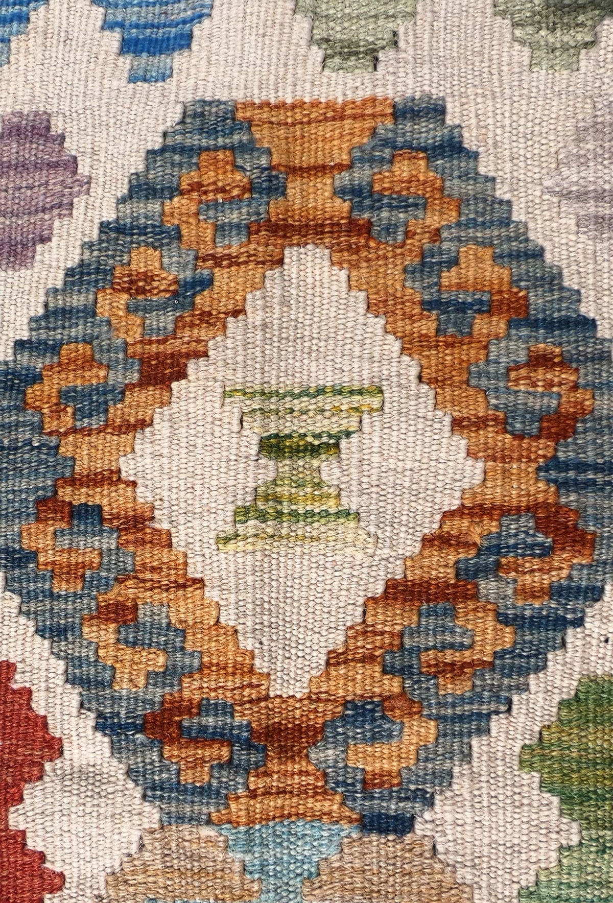 Detalle de motivos geométricos en alfombra Kelim de tejido plano y colorido