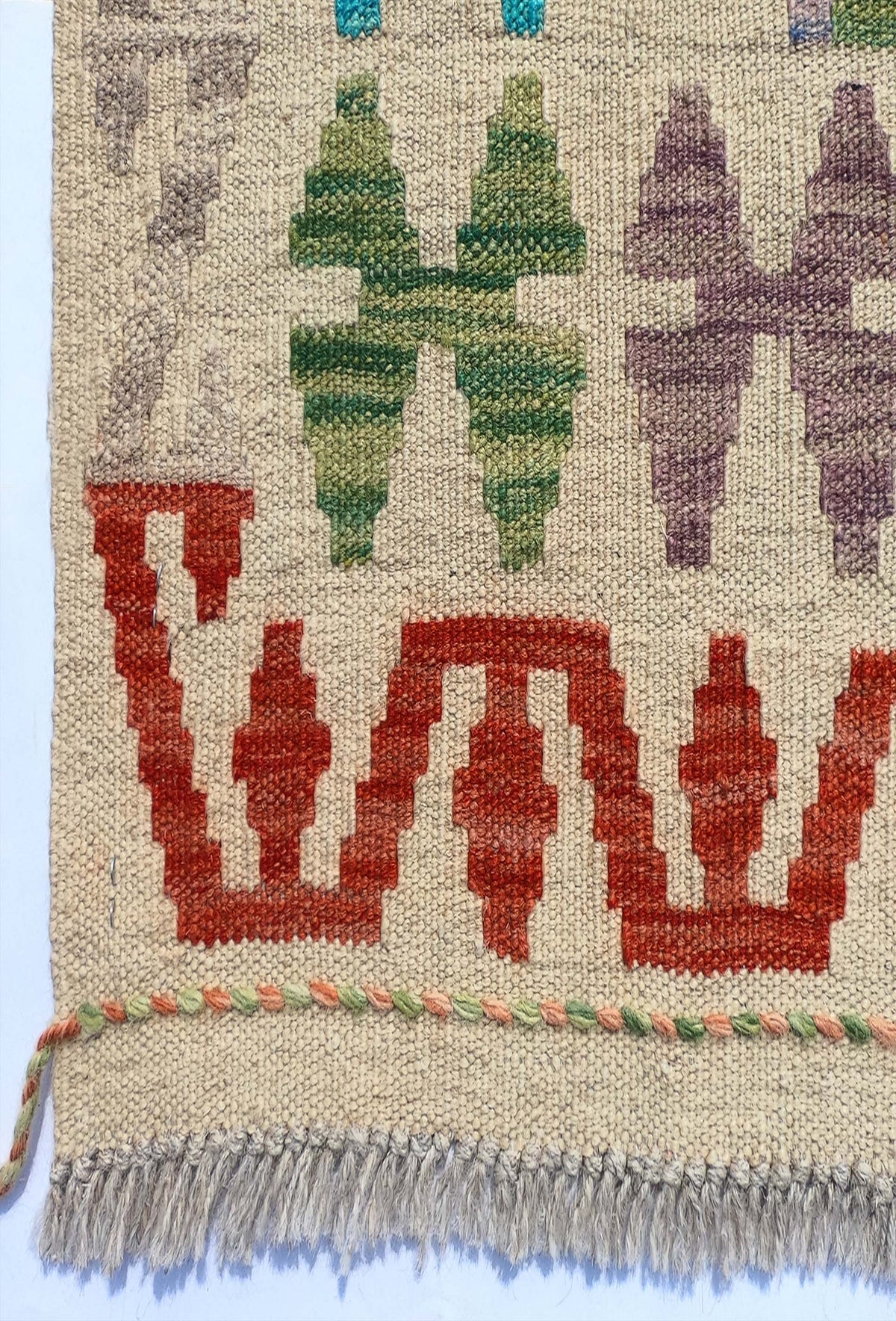 Textura de lana natural en alfombra Kelim artesanal, teñida con tintes naturales
