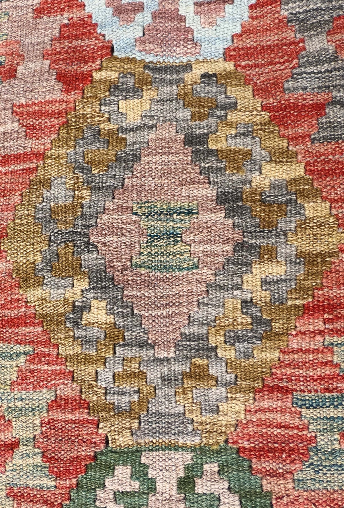 Detalle de motivos geométricos en alfombra kelim de lana artesanal