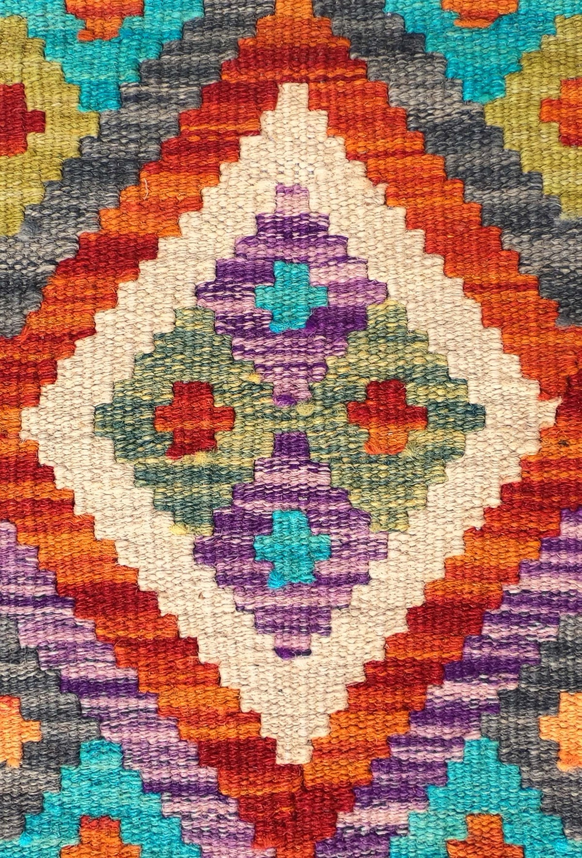 Detalle de motivos geométricos en alfombra Kelim de lana tejida en telar