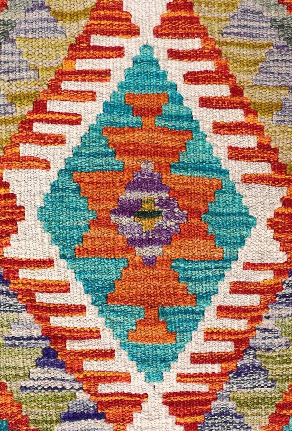 Detalle de motivos geométricos coloridos en alfombra Kelim de lana