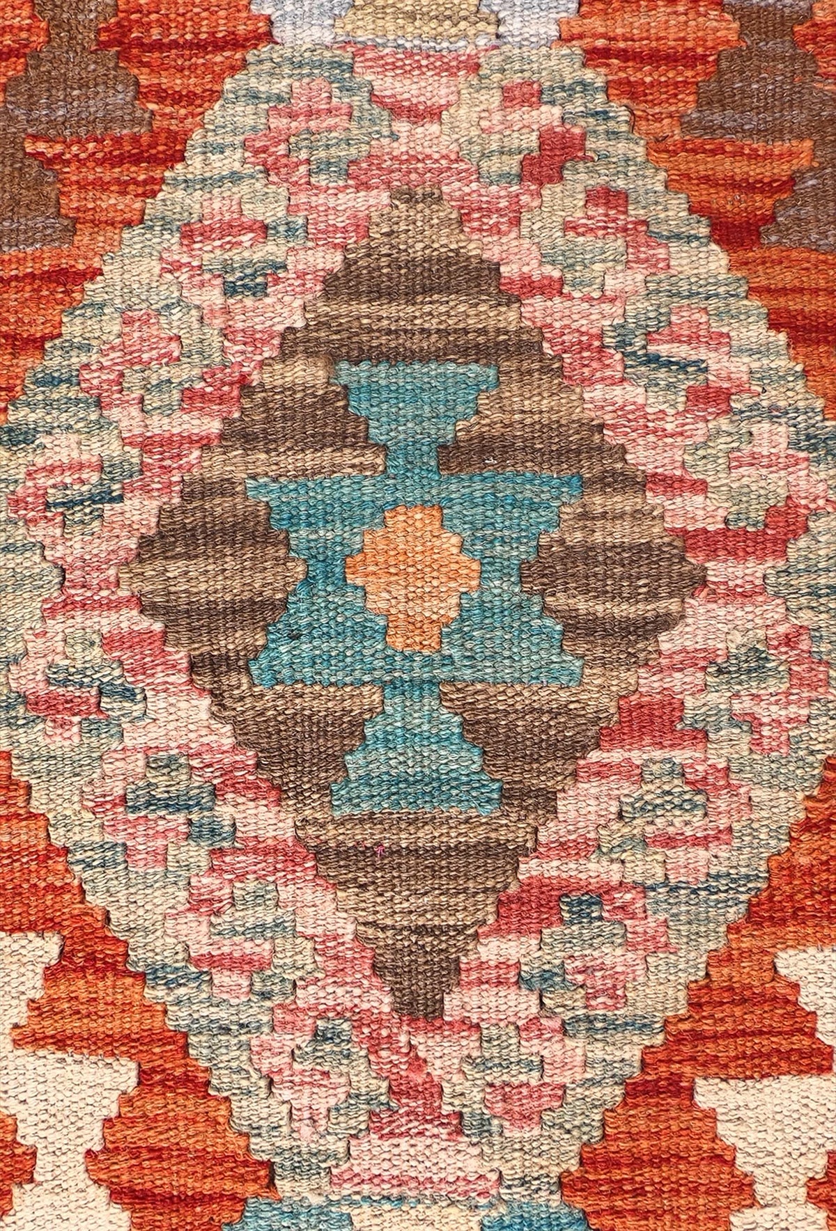Detalle de motivos geométricos coloridos en alfombra Kelim de lana