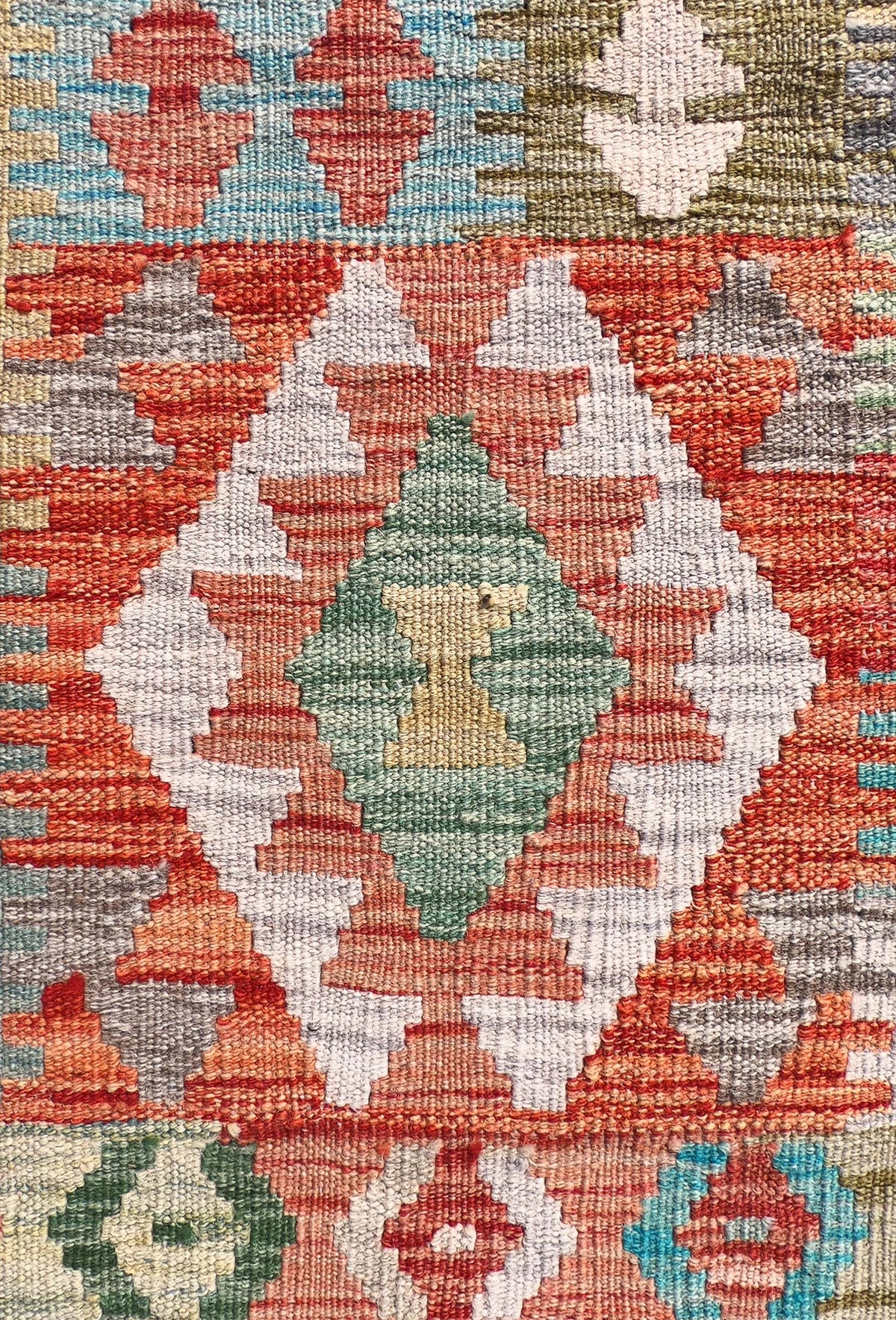 Detalle de patrón geométrico reversible en alfombra Kelim de lana teñida naturalmente