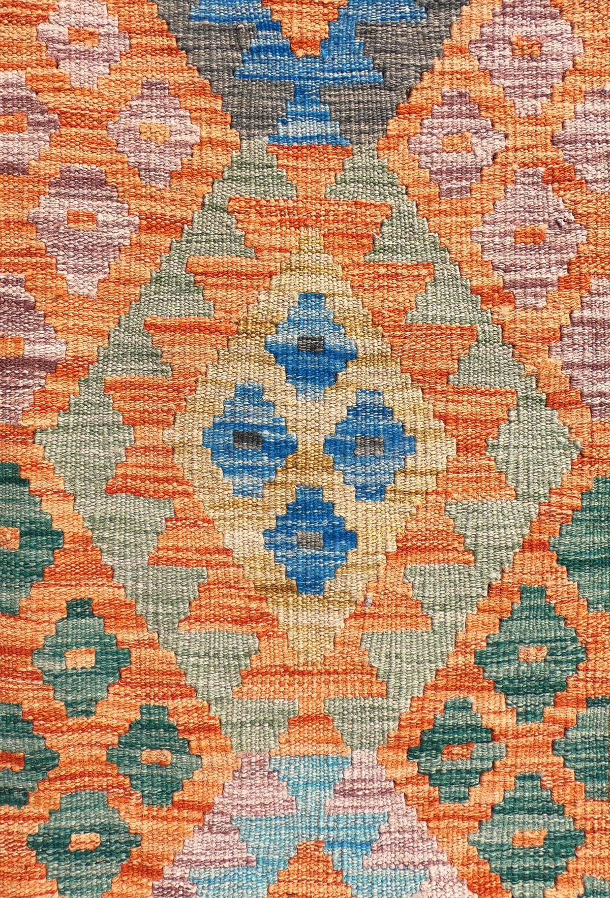 Detalle de motivos geométricos coloridos en alfombra Kelim de lana
