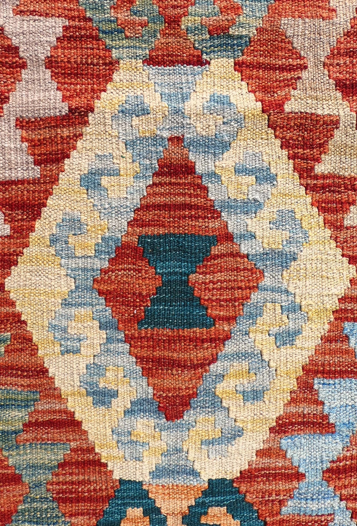 Detalle de patrones geométricos en alfombra Kelim de lana importada