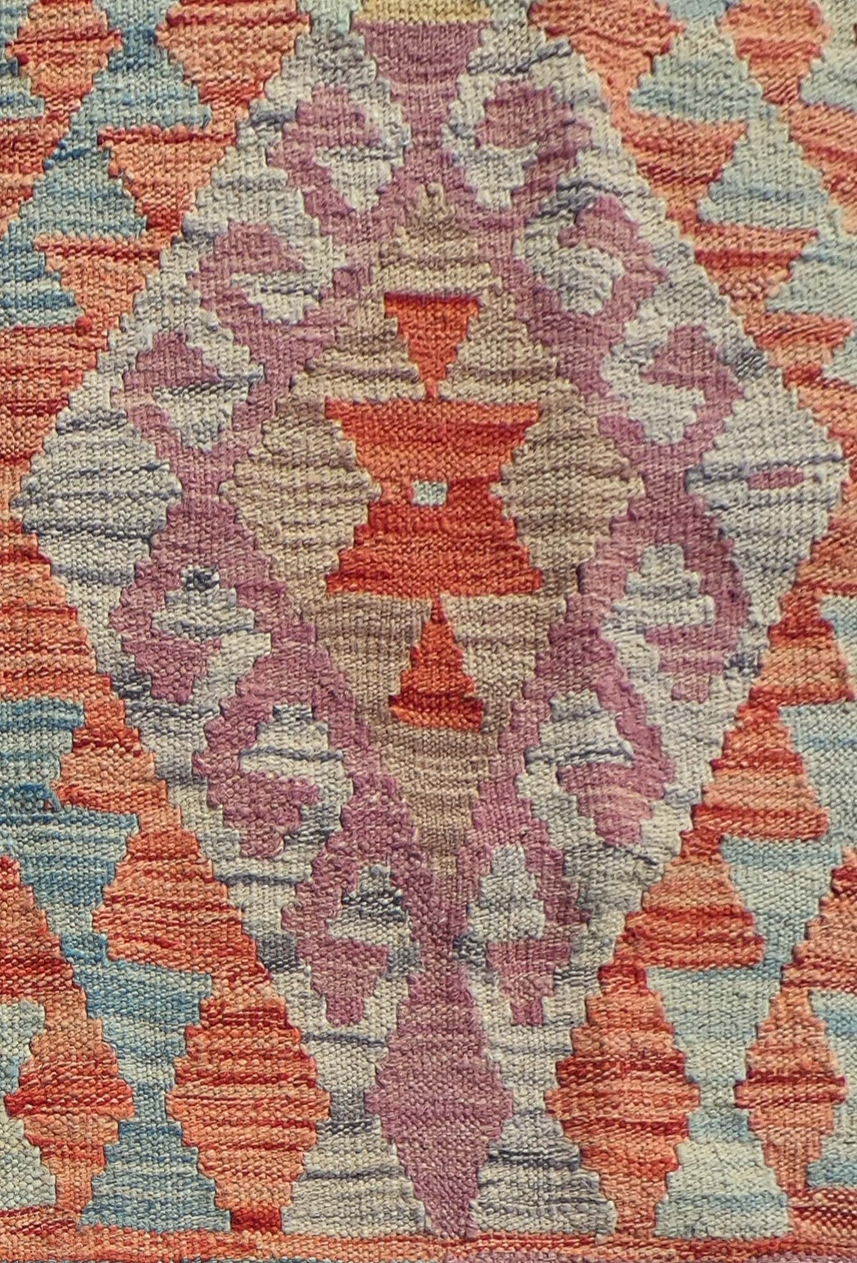 Detalle de patrones geométricos coloridos en alfombra kelim de lana