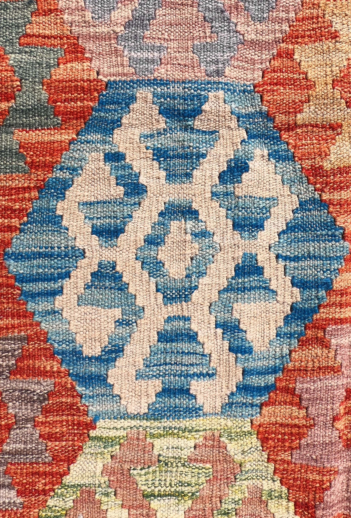 Detalle de motivos geométricos en alfombra kelim de lana artesanal