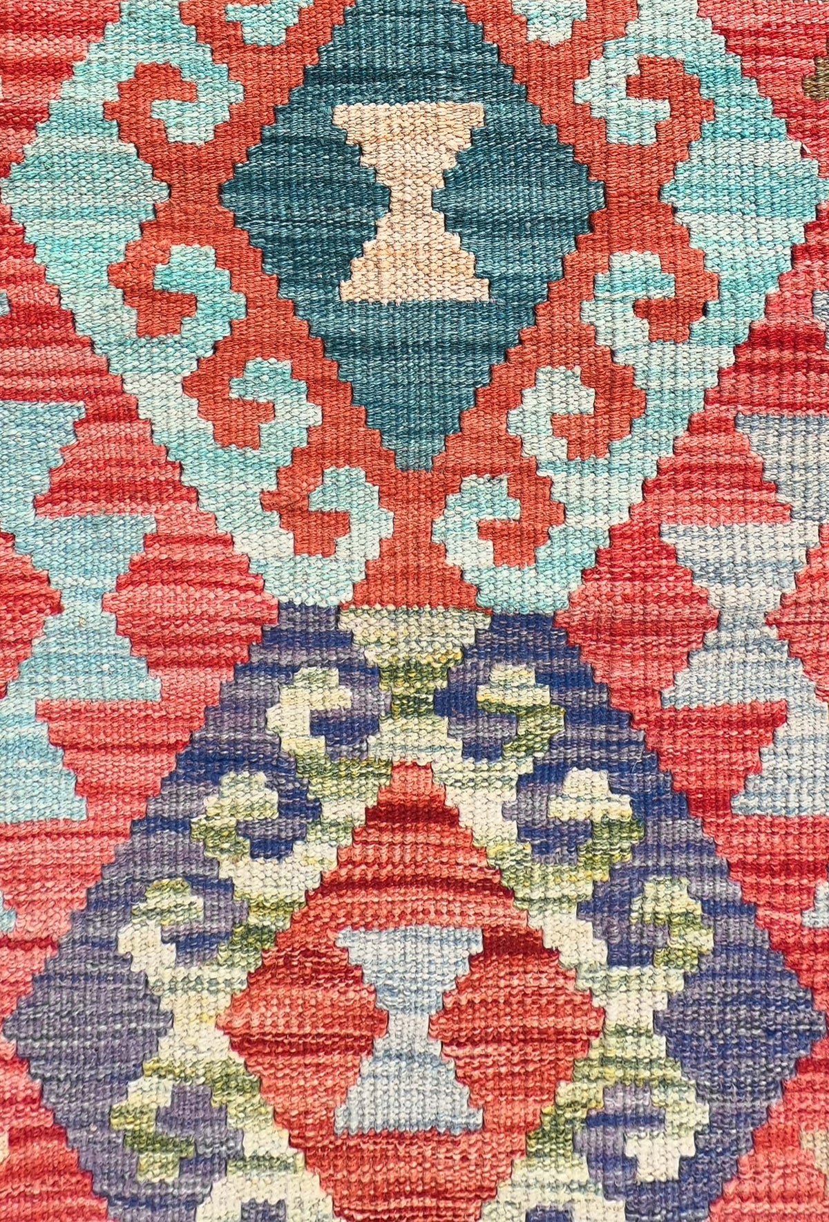 Detalle de motivos geométricos coloridos en alfombra Kelim de lana