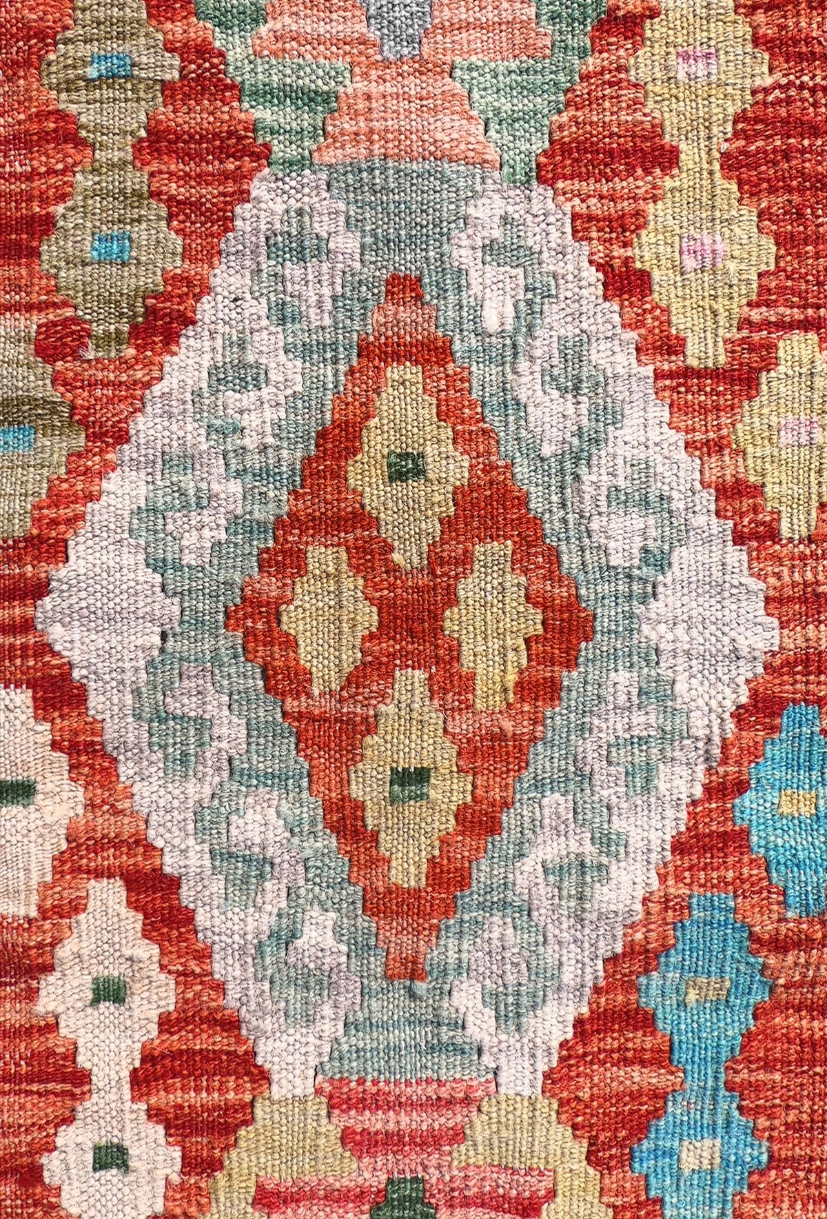 Detalle de motivos geométricos coloridos en alfombra Kelim de lana