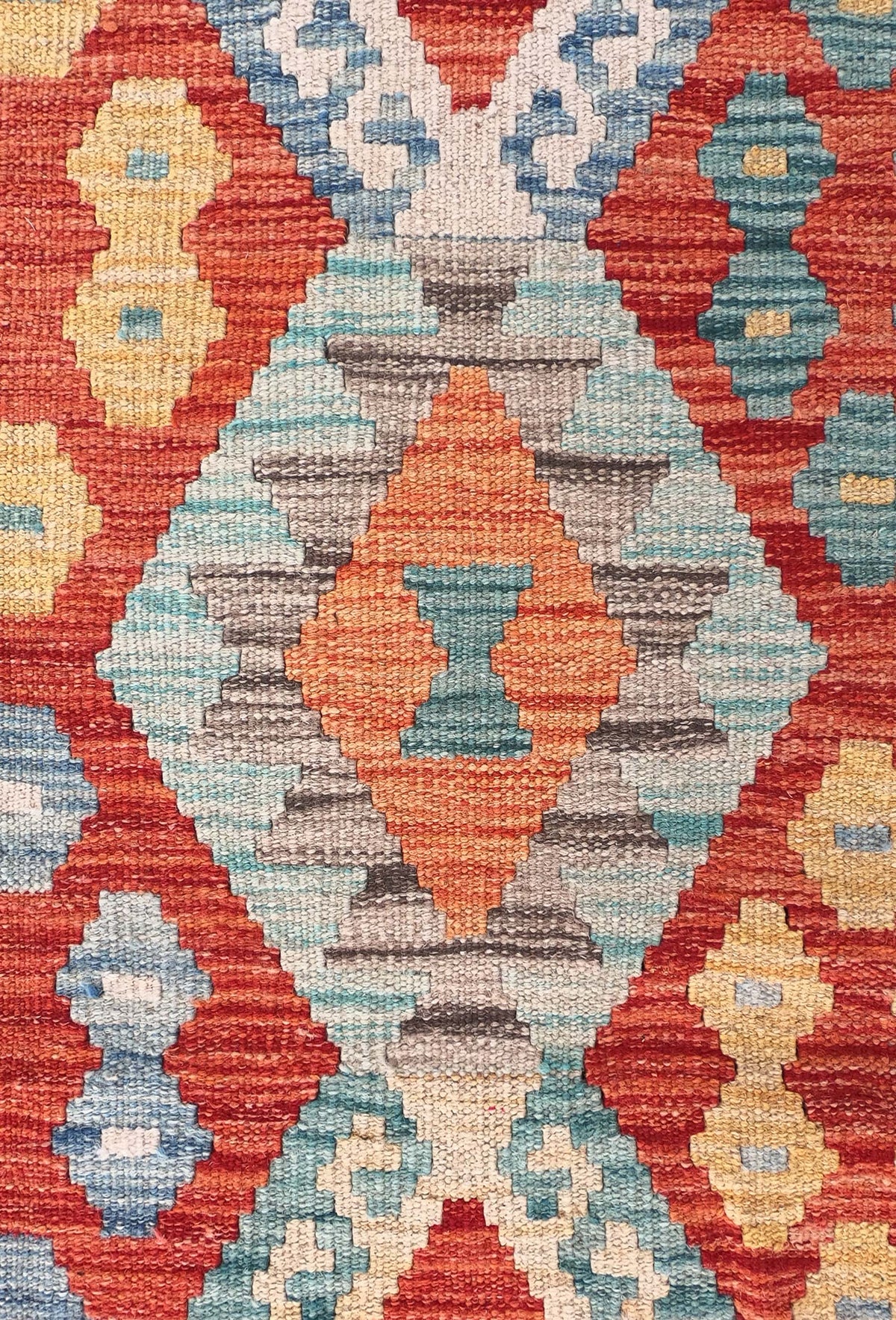 Detalle de motivos geométricos en alfombra Kelim de lana tejida en telar