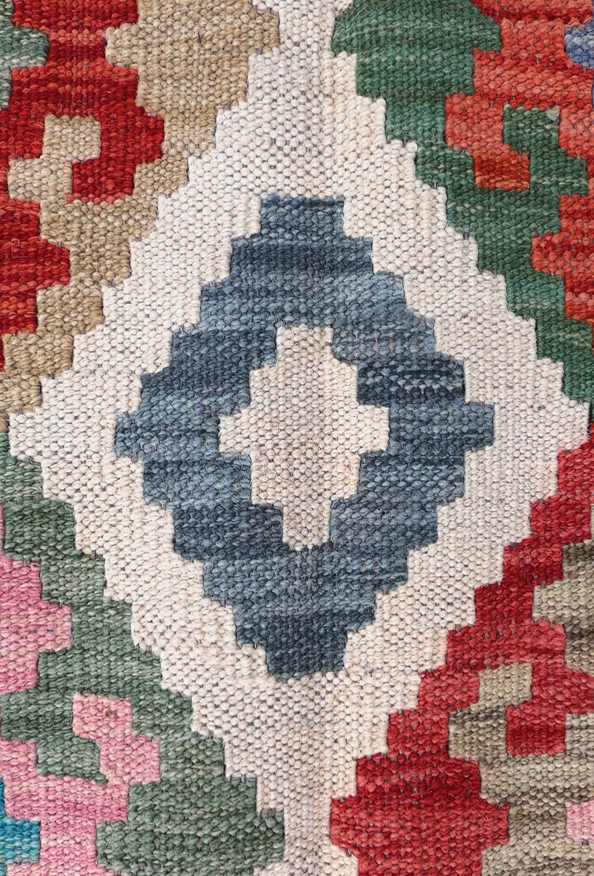 Detalle de patrones geométricos coloridos en alfombra Kelim de lana