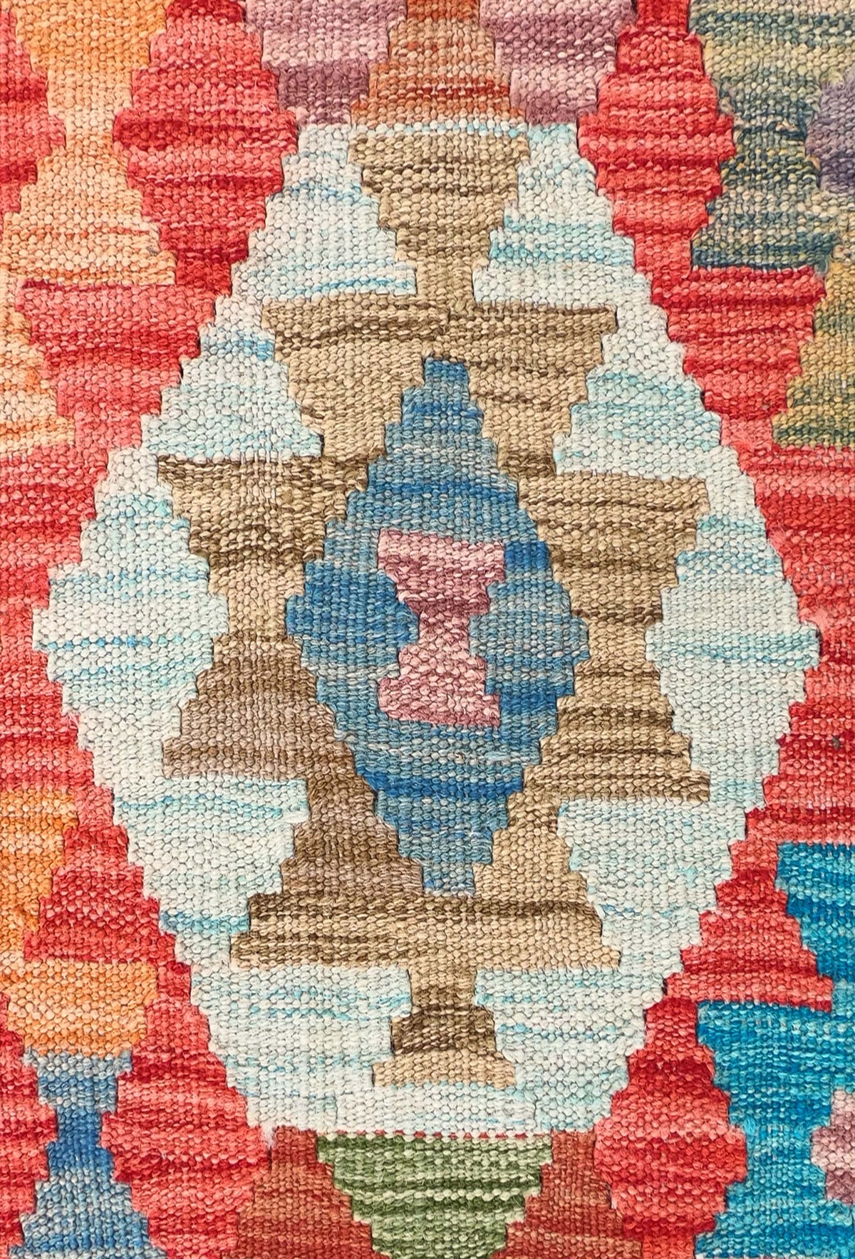 Detalle de motivos geométricos coloridos en alfombra Kelim de lana