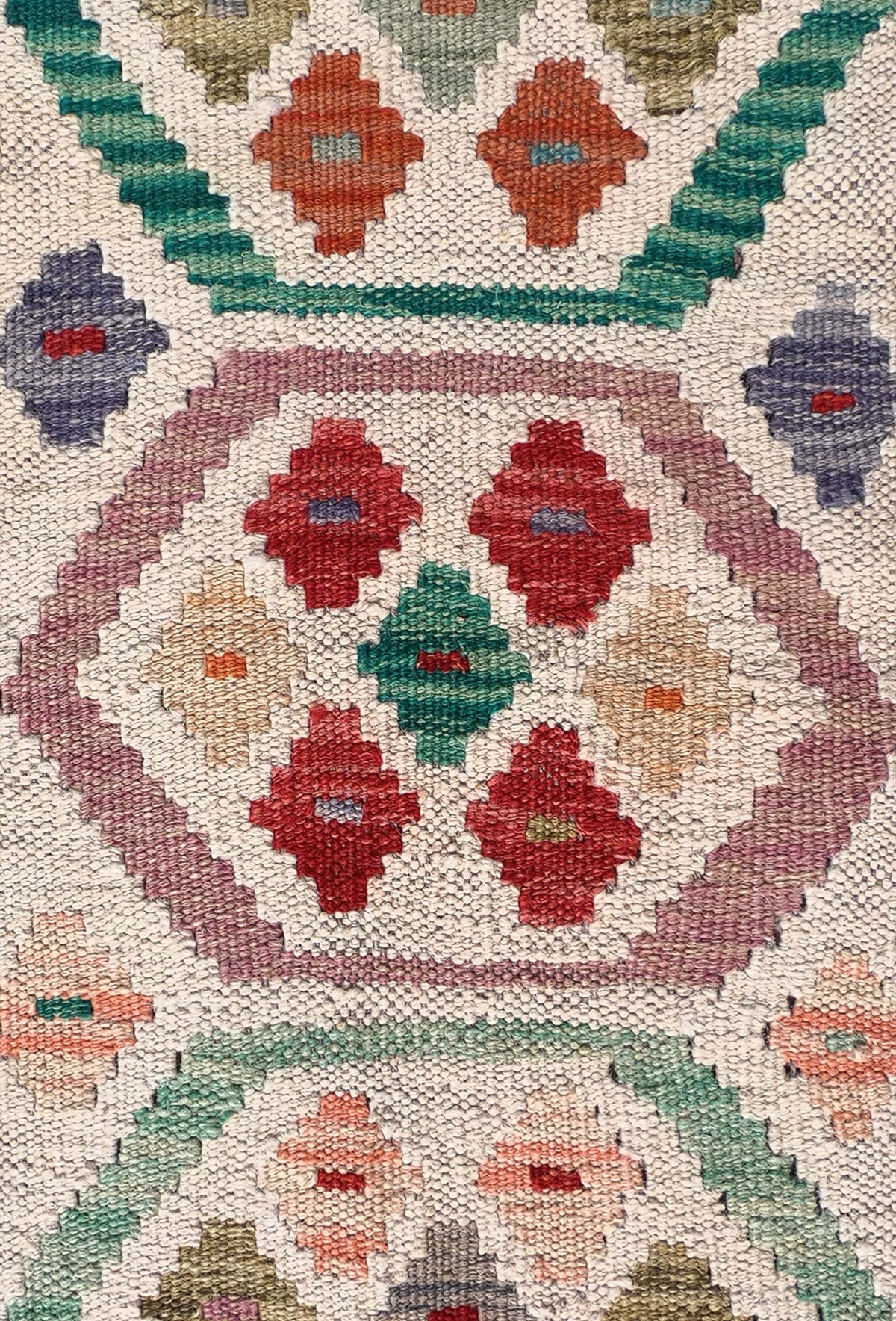 Detalle de motivos geométricos coloridos en alfombra Kelim de lana