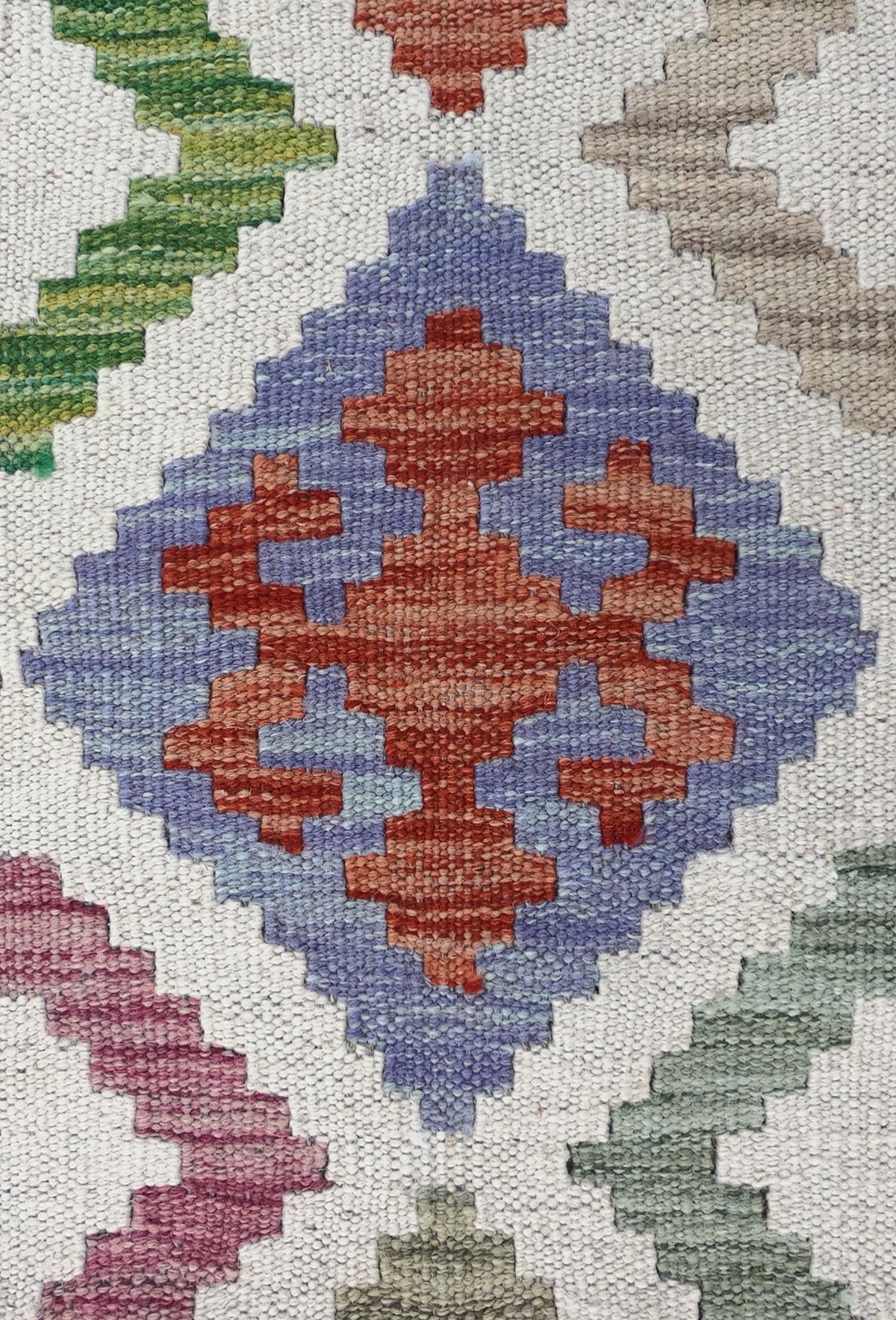 Detalle de patrones geométricos en alfombra Kelim de lana tejida a mano