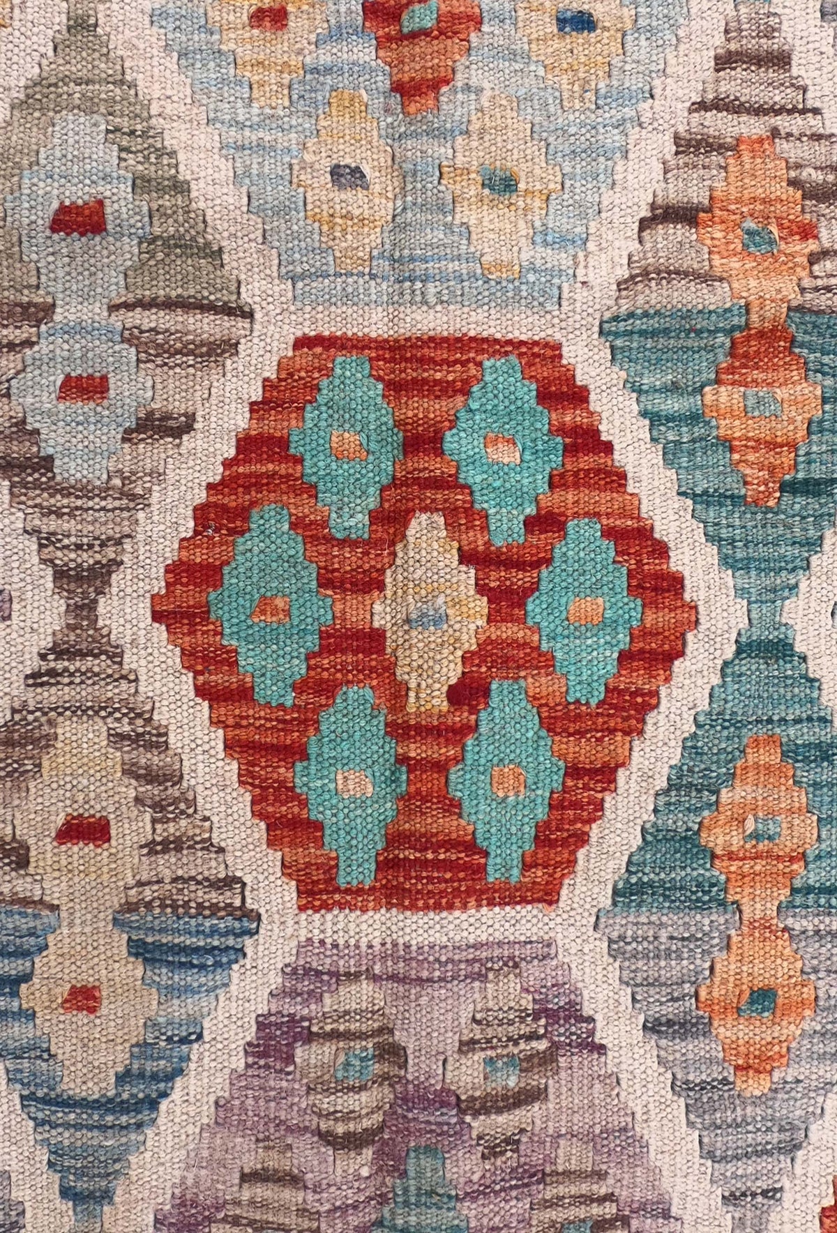 Detalle de motivos geométricos en alfombra kelim de lana tejida plana